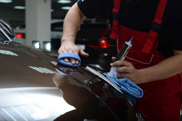 View of a professional repairing a car paint scuff.